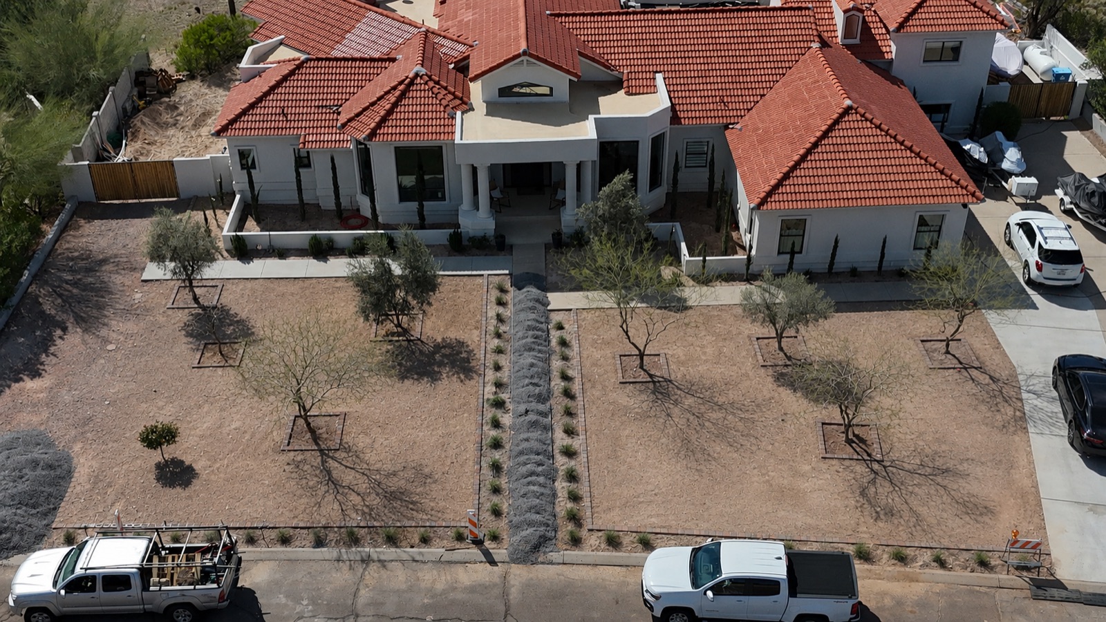 Before: estate front yard, bare dirt with tree squares