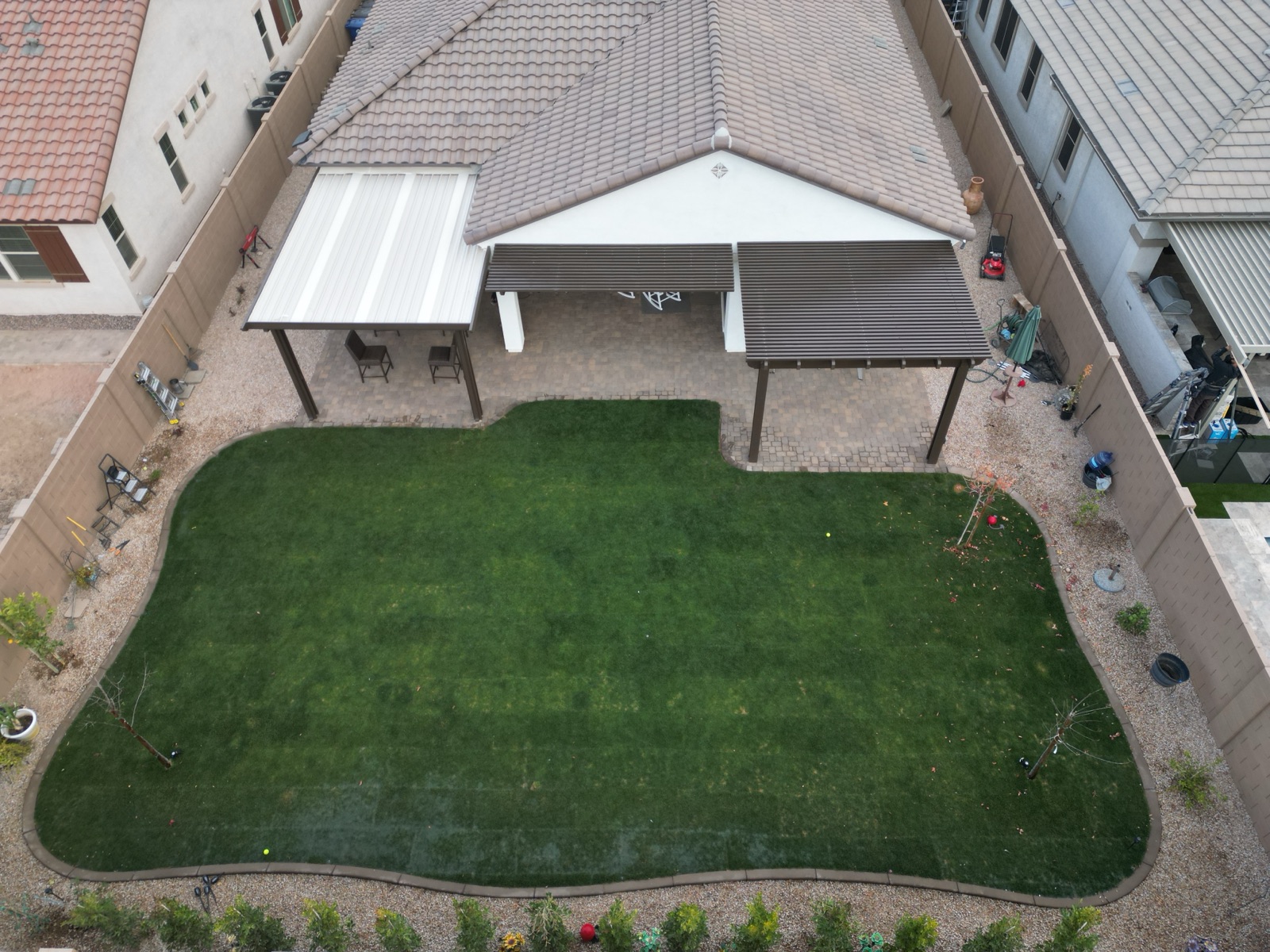After: full green backyard sod fitted around pergolas and pavers